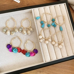 Detailed set of four gold boho hoop earrings with turquoise, shell, and bead charms