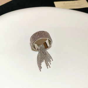 Detail of silver beaded ring with dangling metallic fringe tassels and textured surface