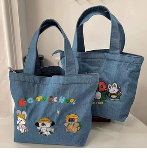 Close-up of Japanese cartoon embroidery on blue denim tote bags with cute animal motifs