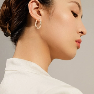 Polished stainless steel hoop earrings for men and women on a fashion model