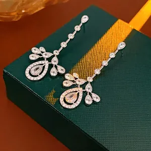 Elegant silver tassel earrings with zircon waterdrop charms on a green gift box