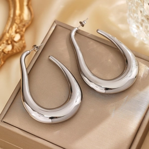 Close-up of teardrop hoop earrings in polished silver finish on a luxury jewelry box