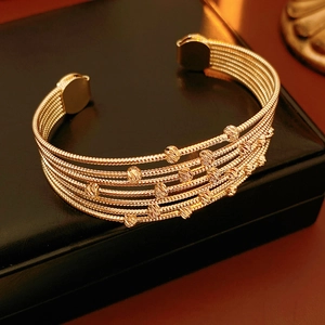 Vue détaillée de bracelets à billes dorées multicouches sur un coffret en cuir