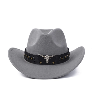 Détail d'un chapeau de cow-boy gris avec bandeau en cuir riveté et emblème tête de taureau