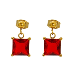 Detailed shot of gold earrings featuring square red gemstone pendants and butterfly clasps