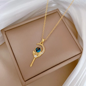 Detail of gold magic wand necklace with blue crescent moon pendant and white diamonds
