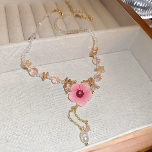 Detail of flower pendant necklace with crystals, pink floral motif and pearl tassels