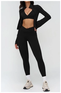 Detail view of black high-waisted yoga leggings featuring side pockets and cross-waist design