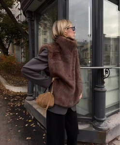 Détail d'un gilet en fausse fourrure marron avec blazer gris pour un look d'automne chic