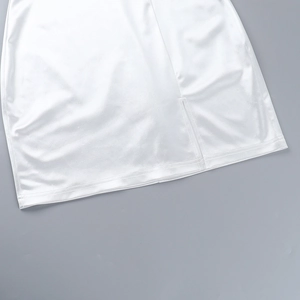 Detailed close-up of a white satin dress hem featuring a clean side slit design