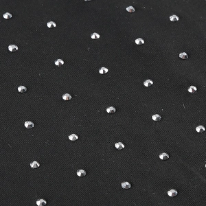 Detail of black fabric featuring rows of shiny silver rhinestones and fine knit texture