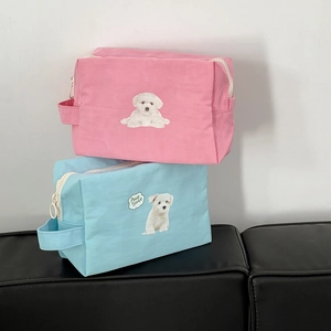 Close-up of cute dog print cosmetic bags in pink and blue with smooth fabric texture