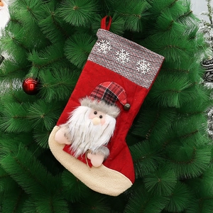 Large Christmas stocking with 3D Santa Claus hanging on a green Xmas tree