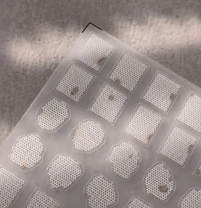Close-up of white lace pattern nail stickers with matte translucent geometric textures