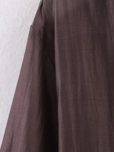 Close-up of brown cotton linen shirt showing shoulder seam and natural fabric texture