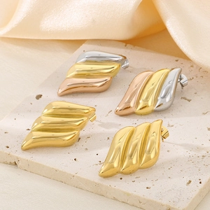 18K gold-plated angel wing earrings in gold and tri-color finishes on a stone display