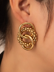 Detail of gold-plated double-loop earrings with polished finish and beaded texture