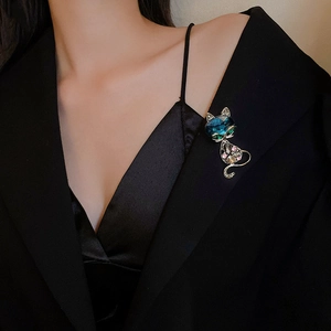 Detail showing a crystal fox brooch with blue and green rhinestones pinned to a dark suit