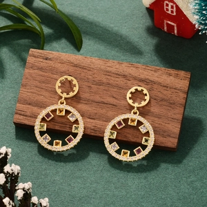 Detail of round gold earrings with colorful zircon stones on festive wooden display