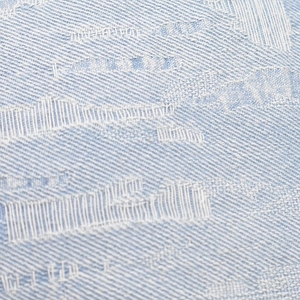 Macro shot of light blue distressed denim fabric with white woven jacquard texture details