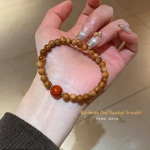 Handcrafted brown Kuka wood bead bracelet featuring red agate and golden spacer beads