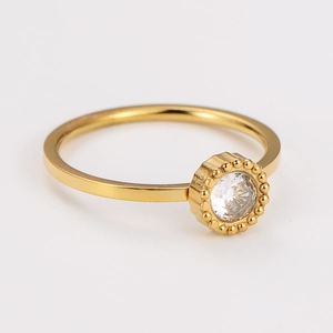 Detailed macro view of gold plated stainless steel ring with round zircon and beaded edge
