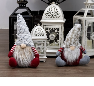 Detail of two Christmas gnomes with knit hats and faux fur beards on wood floor