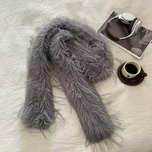 Flat lay of a grey faux fur scarf with headphones and coffee for a cozy winter vibe