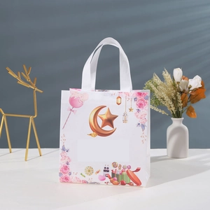 White non-woven Ramadan gift bag with gold crescent moon, stars and festive prints
