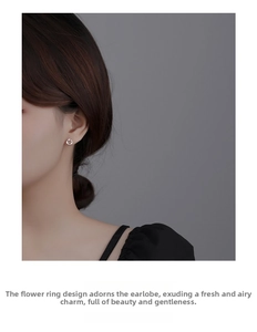 Close-up of S925 sterling silver floral wreath stud earrings worn on a model ear