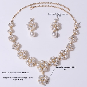 Detailed view of floral pearl necklace and earrings set with gold finish and rhinestones