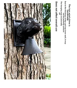 Detailed view of a cast iron dog head doorbell mounted on a rustic tree trunk outdoors