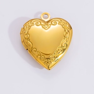 Detailed close-up of heart-shaped gold locket pendant with intricate floral engraving