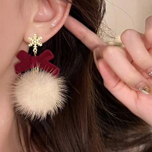 Christmas snowflake earrings with red velvet bow and white fuzzy pom pom on model