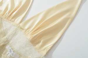 Gros plan détaillé du satin crème et de la dentelle délicate sur une robe à décolleté en V