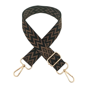 Detail of adjustable woven shoulder strap with brown diamond patterns and gold hooks