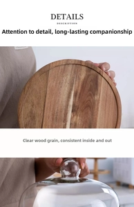 Detail view of round wooden cake tray with clear glass dome and natural wood grain texture