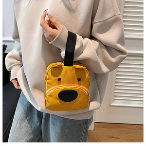 Detail of yellow cartoon dog tote bag with fabric texture and 3D ears shown by model
