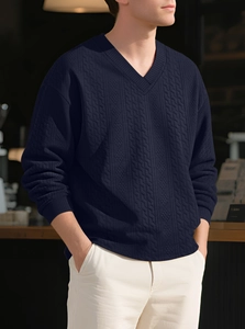 Detailed view of dark blue V-neck cable knit sweater showing intricate vertical patterns