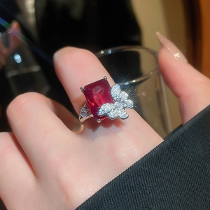 Detail of elegant silver ring with large rectangular ruby and micro-pave butterfly accents