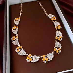 Vintage zircon leaf pendant necklace with gold finish and amber crystals in jewelry box