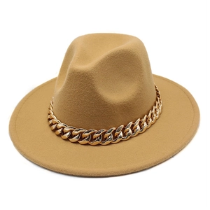 Close-up of a camel wool fedora hat featuring a bold decorative gold chain on the brim