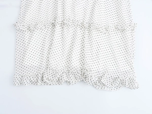Détail de l'ourlet à volants superposés sur la robe blanche à pois avec plusieurs épaisseurs