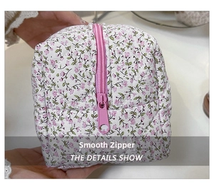 Detail of pink floral quilted cosmetic bag featuring a smooth resin zipper closure