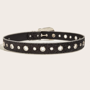Detail of black glitter textured belt with metallic eyelets and buckle on beige background