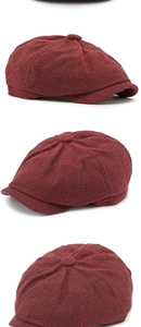 Detail view of red and black herringbone newsboy cap with textured wool fabric and button top