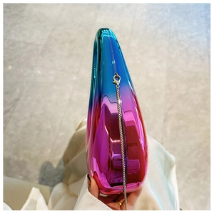 Close-up of a gradient acrylic clutch bag with metallic finish and thin chain strap