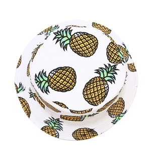 Close-up of white bucket hat with all-over pineapple print and vibrant green leaves