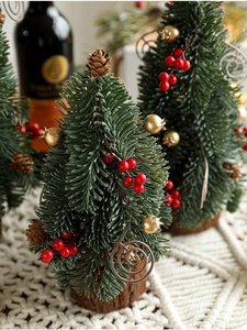 Close-up of mini Christmas trees with red berries and pinecones on wooden bases