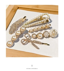 Detail of assorted gold-finish hair clips with elegant pearls and sparkling rhinestones